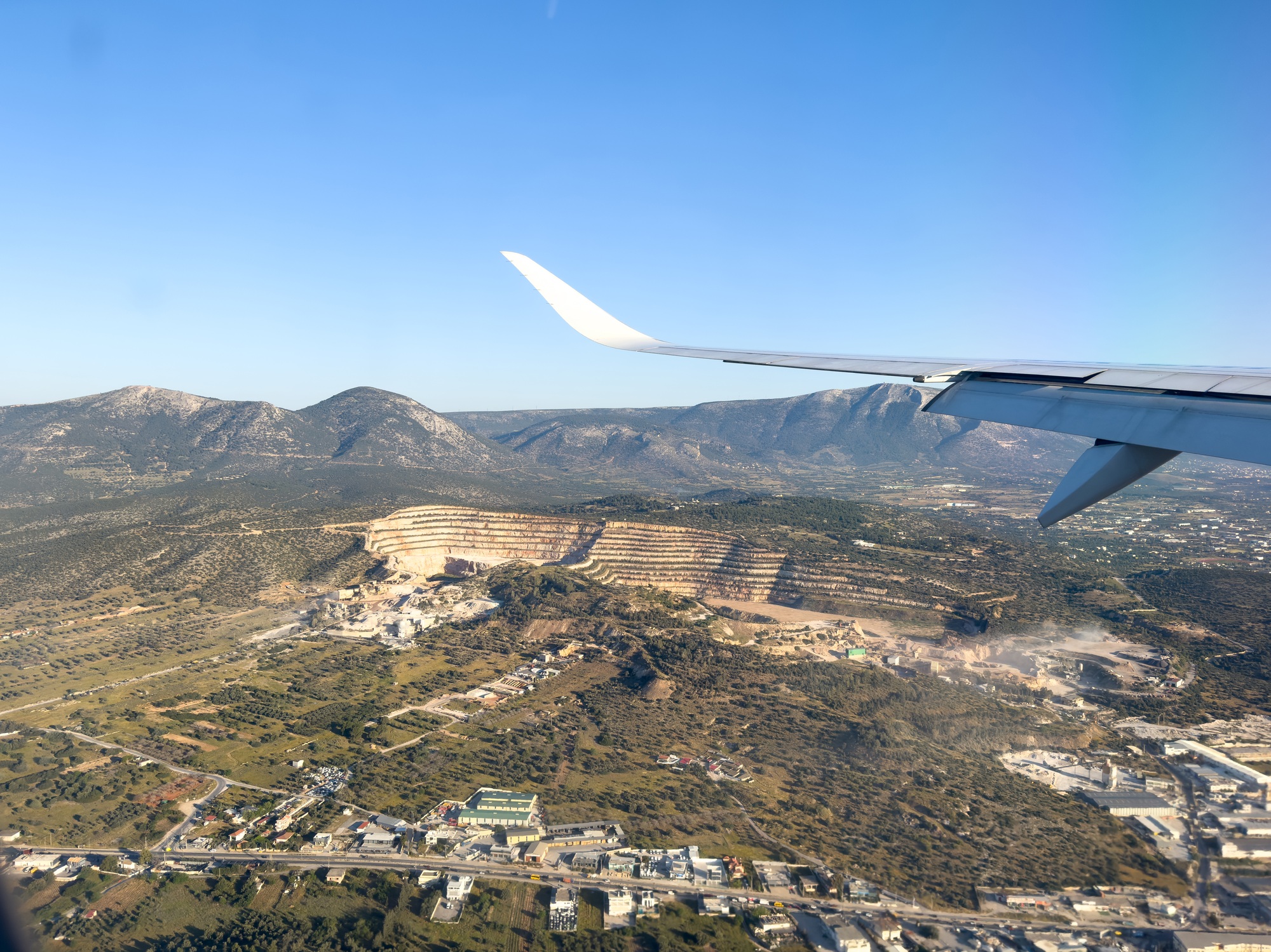 Plane over Athens, Greece. View of a quarry out of airplane window.